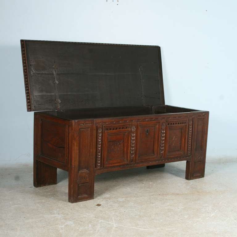 Heavily carved dark oak coffer from Germany, dated 1697. The deep, dark patina reveal the age of over 300 years. Notice the names carved into the 2 front panels, the left reading 