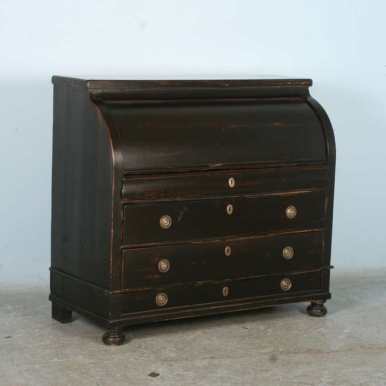 This lovely antique Danish secretary has been given a new black painted finish. The roll top desk opens to reveal 9 drawers, 1 petite cabinet (top center),and 3 sliding panels that create the work surface while closed, but open to reveal storage