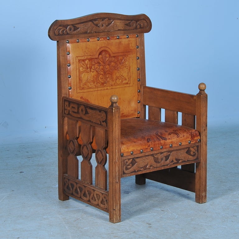 This amazing chair boasts hand carved dragons with necks entwined on the headrest and additional intricate carving on lower front and sides. Internet viewers please use close up function to appreciate the detail in the carving. The embossed leather