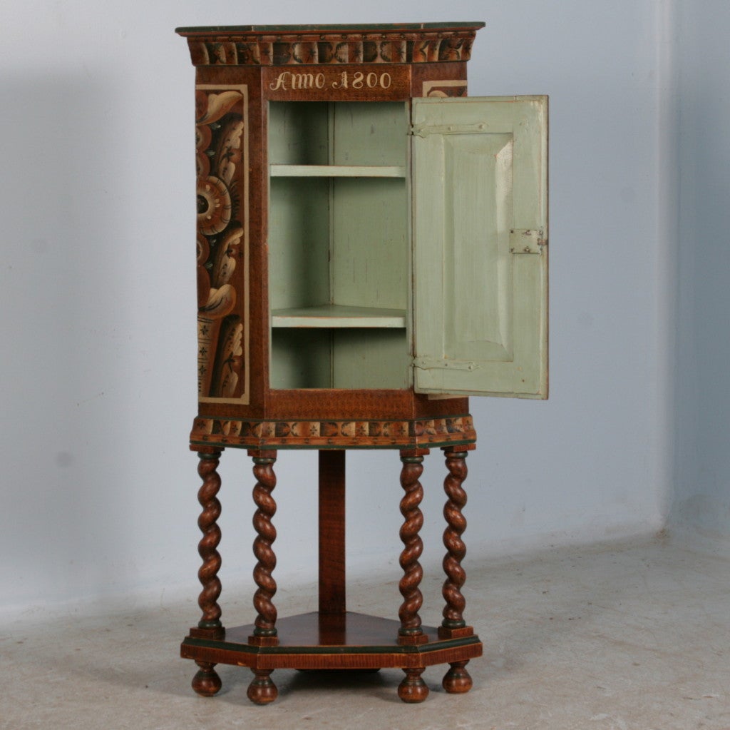 Original Antique Painted Swedish Corner Cabinet. The highly stylized painting on this corner piece was traditional in 1800's Sweden. The barley twist legs were added later, likely 1920's.