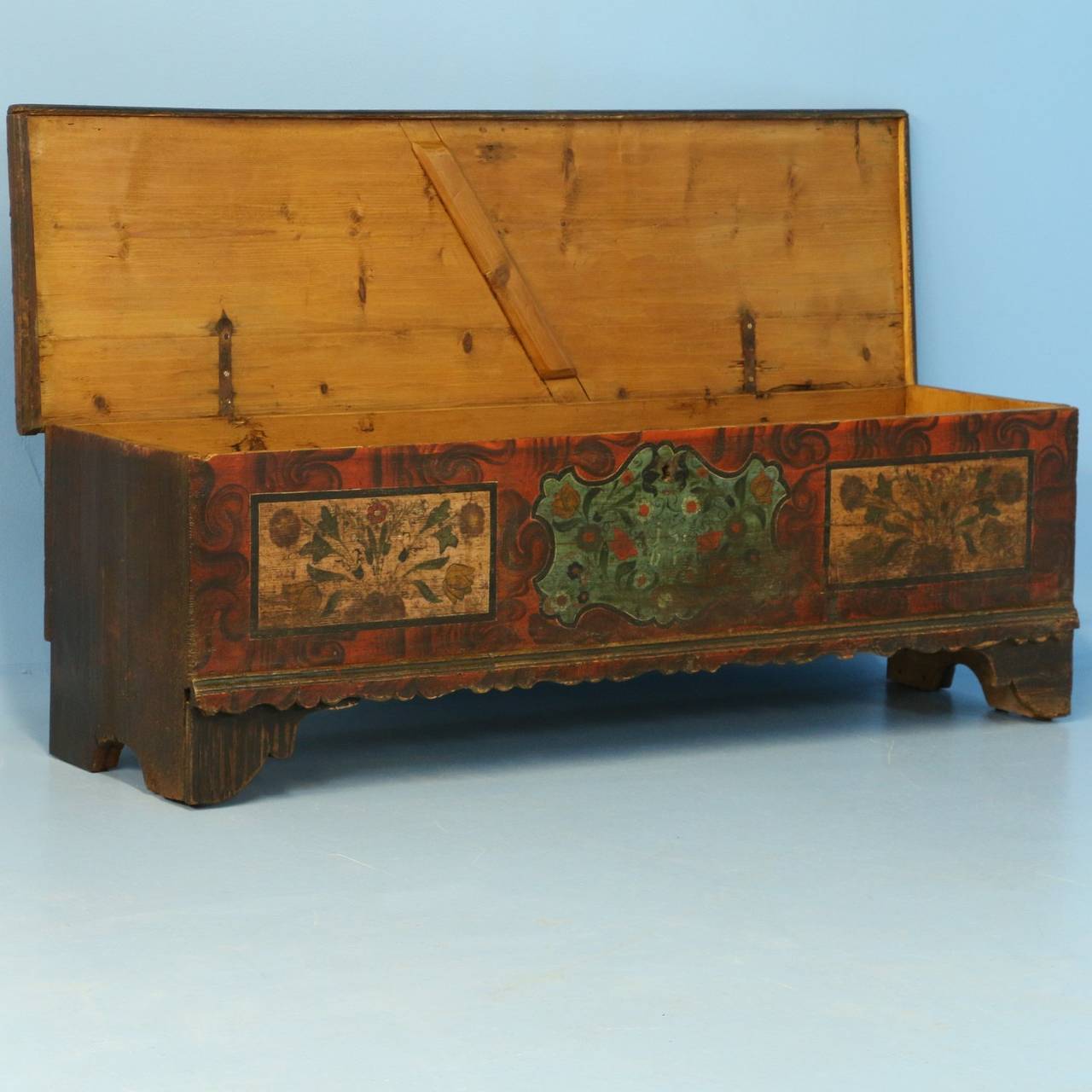 The lovely paint is all original on this narrow trunk from Romania. Please examine the close up photos to appreciate the soft color palette and folk art floral patterns within the 3 painted panels of the front. The date of 1867 can be seen in the