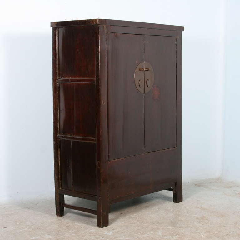 The beauty of this cabinet is in the rich, extremely dark brown color and the clean lines of Chinese styling. The look is made complete with the lovely lacquered finish. When the cabinet doors are opened, a hidden storage area is revealed beneath