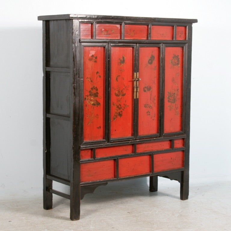 Antiker chinesischer Schrank, rot bemalt/lackiert. Dieses schöne rote Kabinett hat schöne Blumen und Granatäpfel, die auf den Paneelen in schwarzer Farbe und mit Gold hervorgehoben sind. Die einzigartige Verkleidung trägt ebenfalls zur visuellen