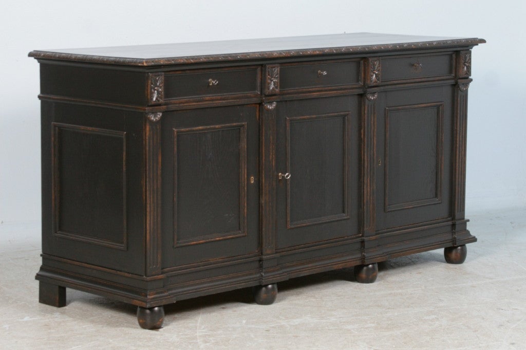 This traditional Danish oak sideboard has been given an updated look with a recent black painted finish. It is slightly distressed (note the close up photos), revealing wood tones below. Perfect size for a buffet or even to use in a master bathroom