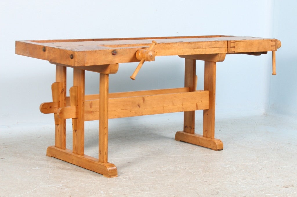 Every scratch and worn edge reveals the decades of service this workbench provided. In today's home, this piece may serve as a unique sofa table, kitchen island or even bar. This workbench was built with a traditional trestle style base which made