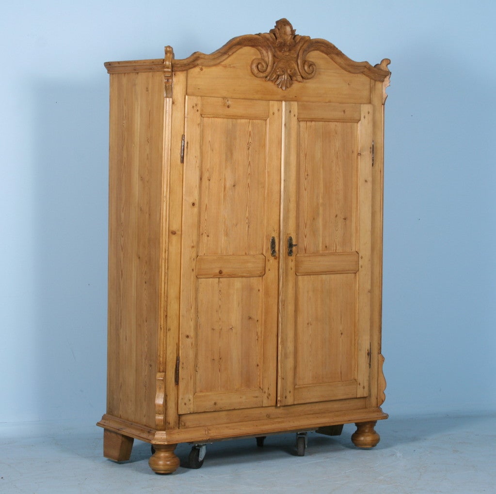 Two Door Pine Armoire with Scroll Detailing. Refined Scrolling detail typical of Lithuania & Baltic region. Piece is in excellent condition and fully restored with natural wax finish. Comes with locking key.Shelves and/or hanging rod may be added,