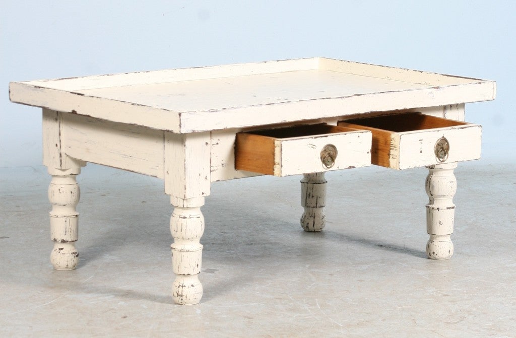 White Painted Coffee Table. This unique pine coffee table is an old piece that has been given a new look with white distressed paint, adding to the country charm of the piece.