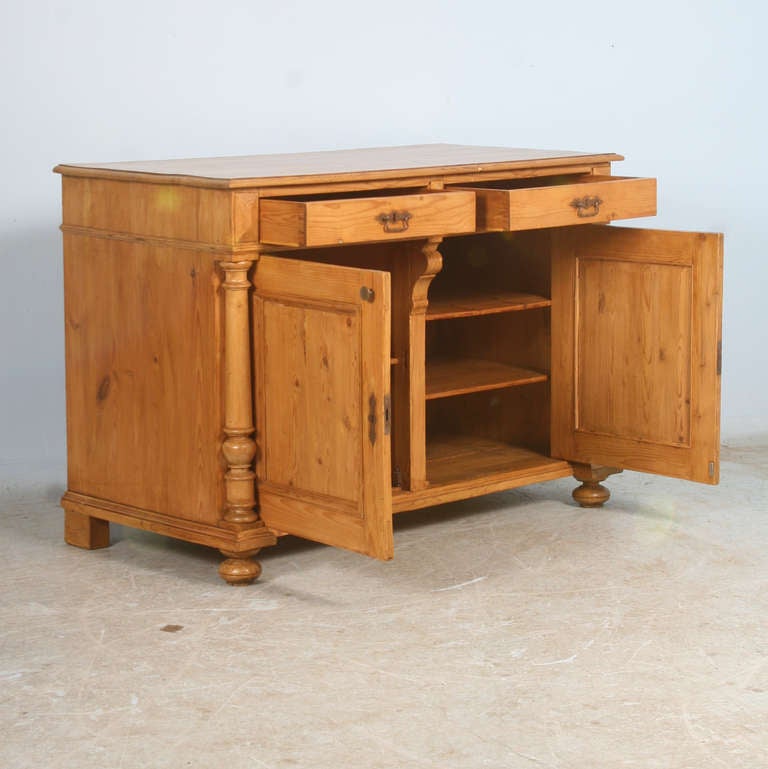 Traditional Danish pine sideboard with turned column details, 2 drawers and bun feet. The entire piece is in excellent condition, ready for use. It has been given a wax finish which compliments the warm pine.