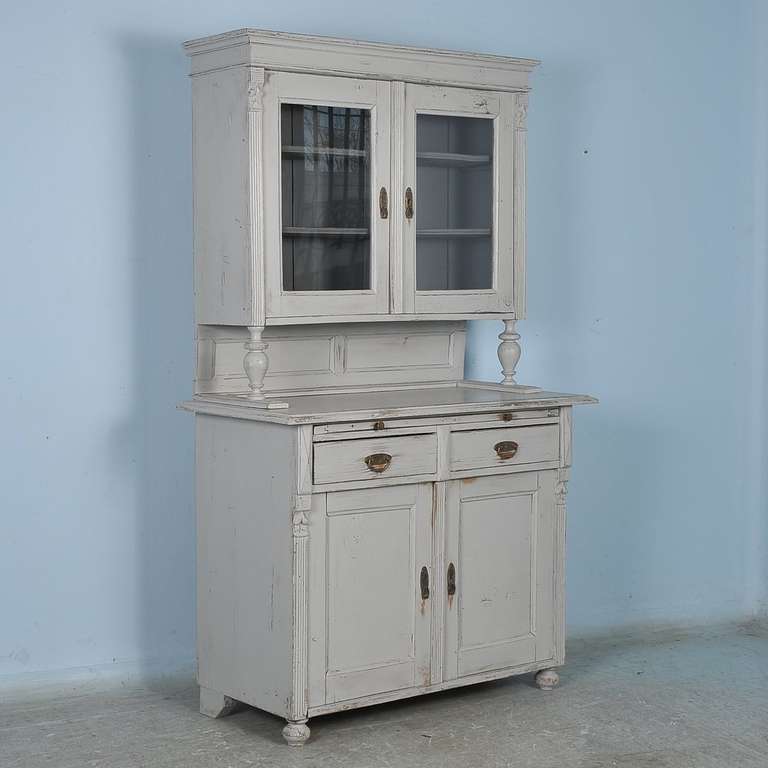 This original pine cupboard  has been given a new, painted finish of a soft grey. The distressed gray finish compliments the European country character and style of the cupboard. Note the close up photos to appreciate the finish. The original
