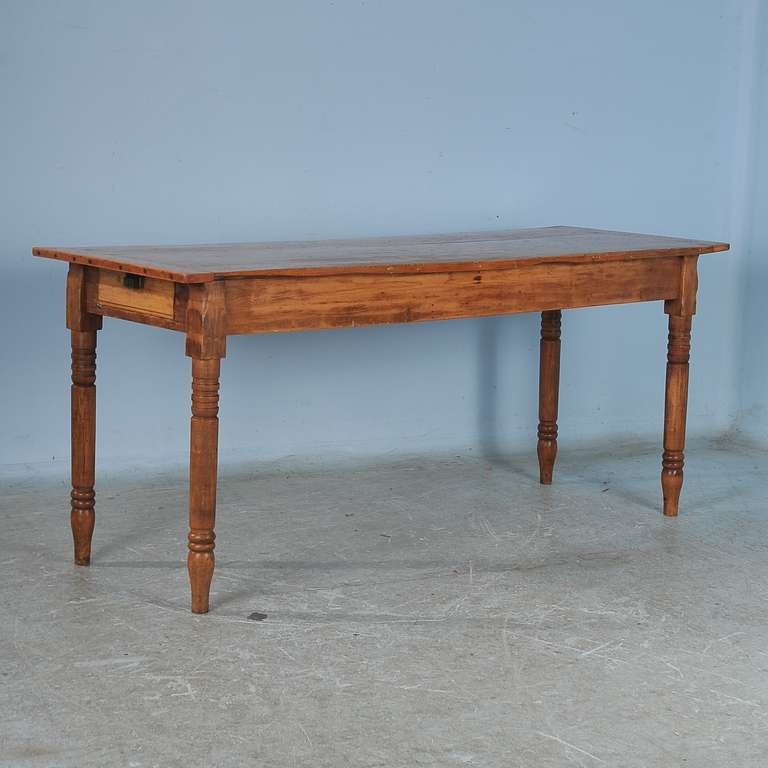 This narrow pine table has a single long, narrow drawer on each end. It is marked underneath, 