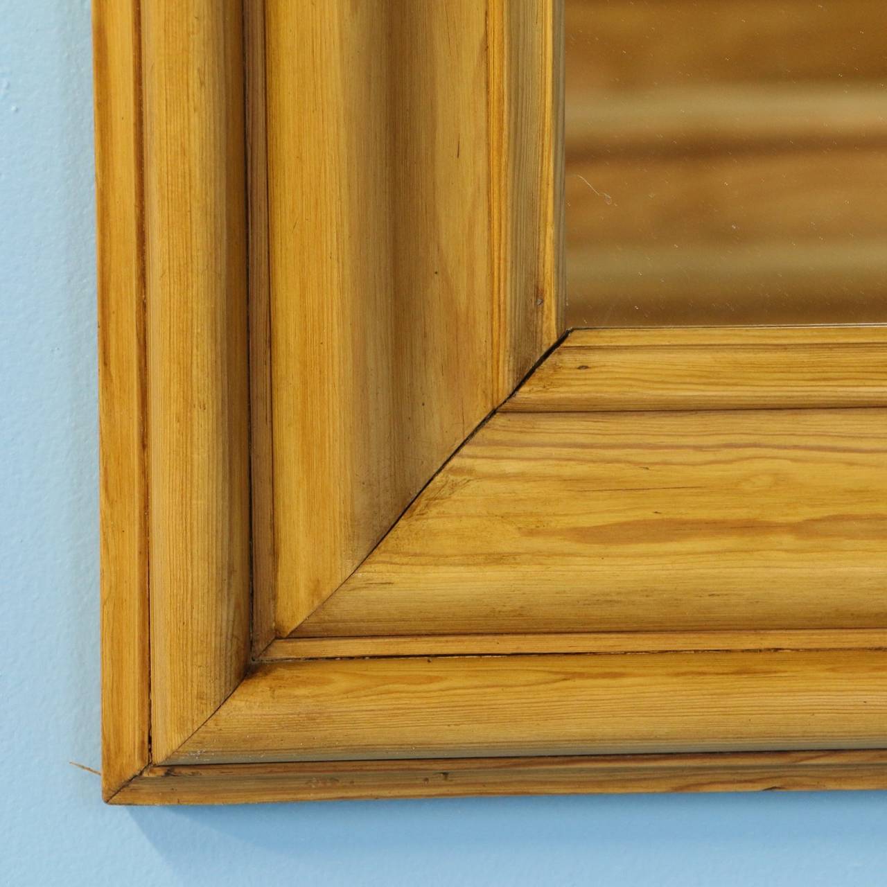 This lovely pine mirror has been given a wax finish, bringing out the warmth of the wood. View the close up photo to appreciate the simple details.