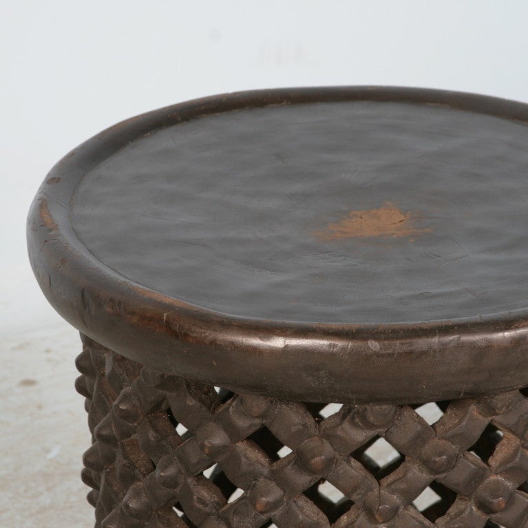 This African side table is made out of a hollowed out tree trunk. It's dark color and intricate detailed carving add to the intriguing organic feel of the piece.  This style of table can be combined with another of different size to create an