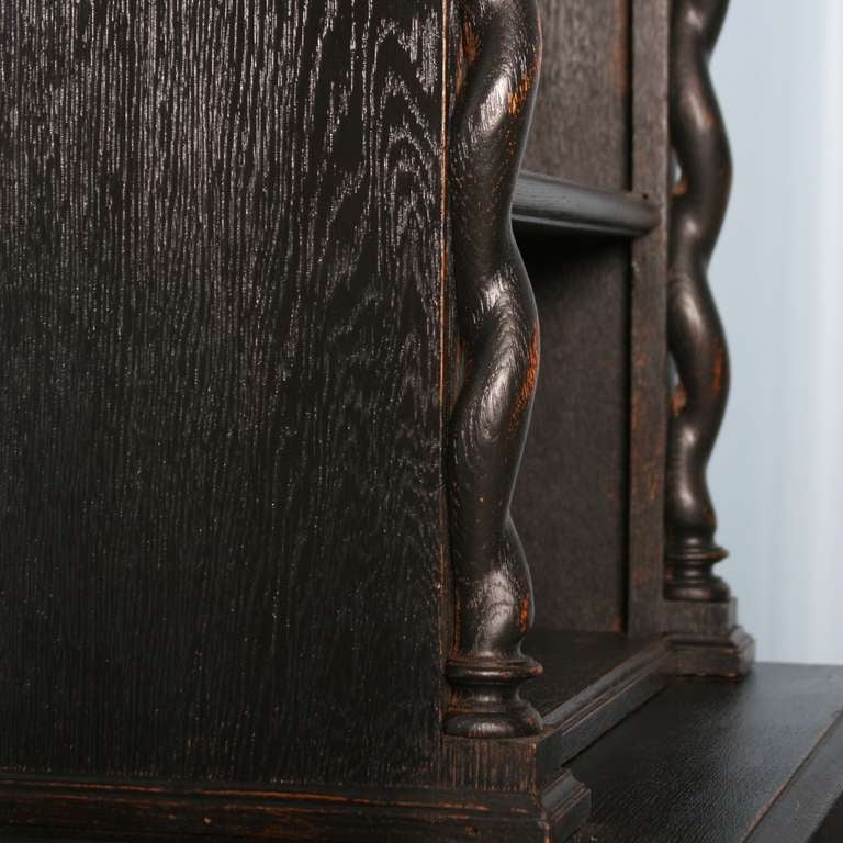 Note the lovely carving and barley twist elements in this narrow bookcase/cabinet. The new black painted finish is slightly distressed, adding extra highlight to these details. The cabinet door opens to reveal interior storage space. 