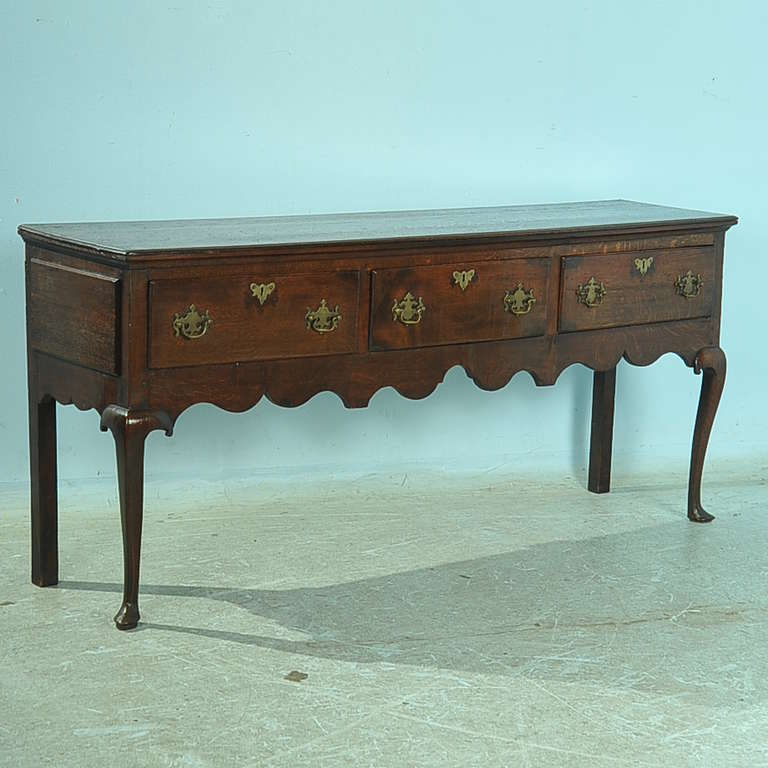 Dark, rich oak wood and elegant lines define this lovely Queen Anne Welsh Dresser, which can be used as a console table, sideboard or serving table in today's home. The gently turned cabriolet legs and original hardware are elements of the Queen