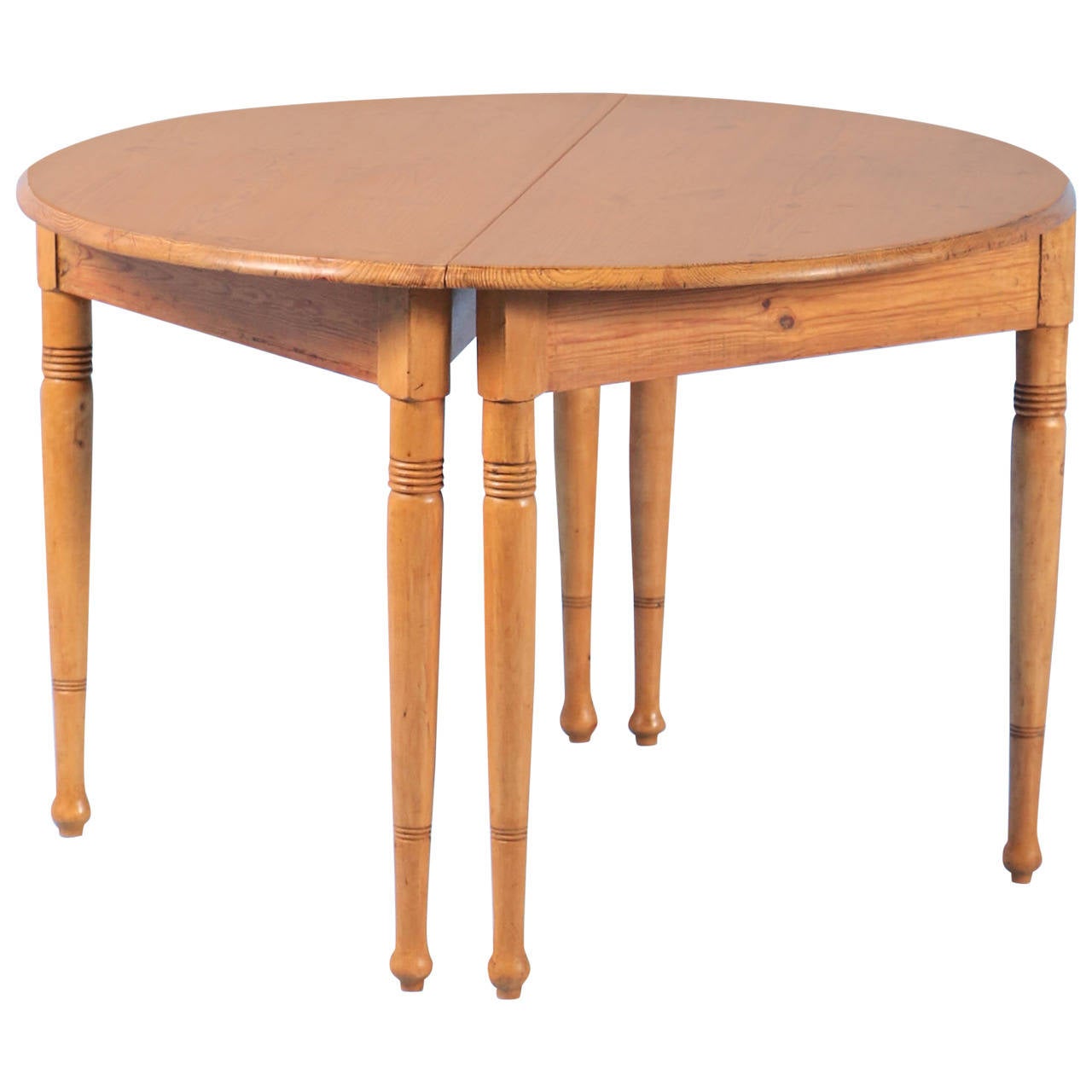 Lovely lines grace the silhouette of this charming pair of Swedish Demi-Lune pine tables. Note the gently turned legs with simple carved detail. The pine has been given a wax finish, bringing out the warmth of the wood. Both tables are solid and