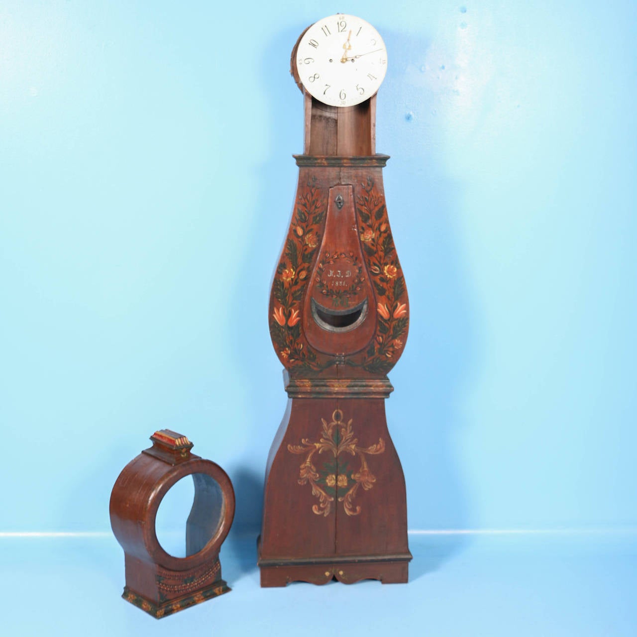 The beautiful paint is all original on this grandfather clock from the famous area of Mora, Sweden. It was painted brown with floral embellishments all around in the traditional Folk Art style of the mid-1800s. The monogram of K.J.D. and date of