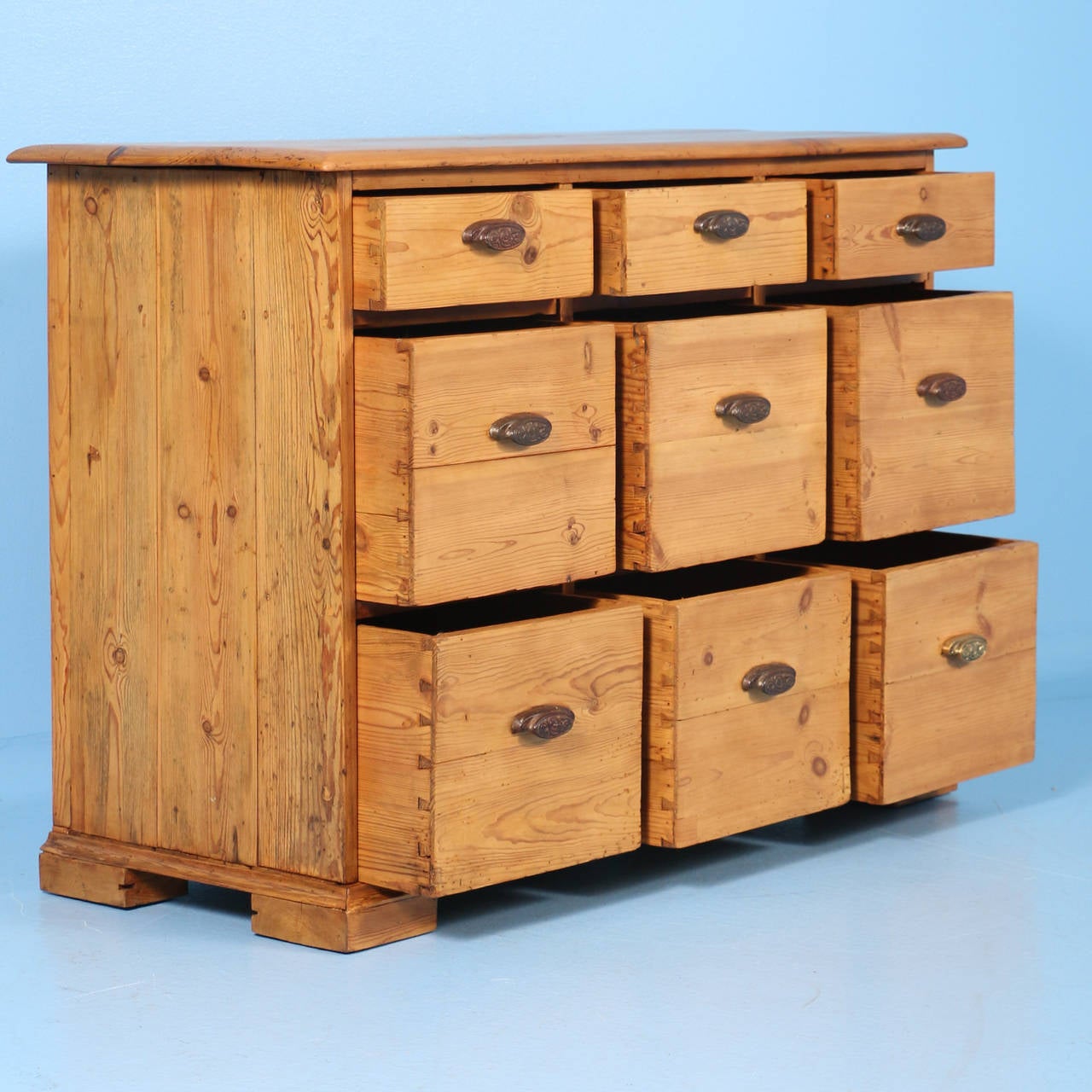 This wonderful chest of nine drawers (six square drawers and three smaller drawers on top) likely served as as small shop counter for display/storage in the mid-1800s of Denmark. While it has the look of an apothecary cabinet, the drawers are