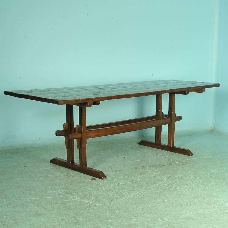 The exceptional, rich patina on this farmhouse table is due to the many years of use. Please view image seven and eight to appreciate the character of the table top. The trestle itself sits inward, allowing easy access to slide chairs and knees