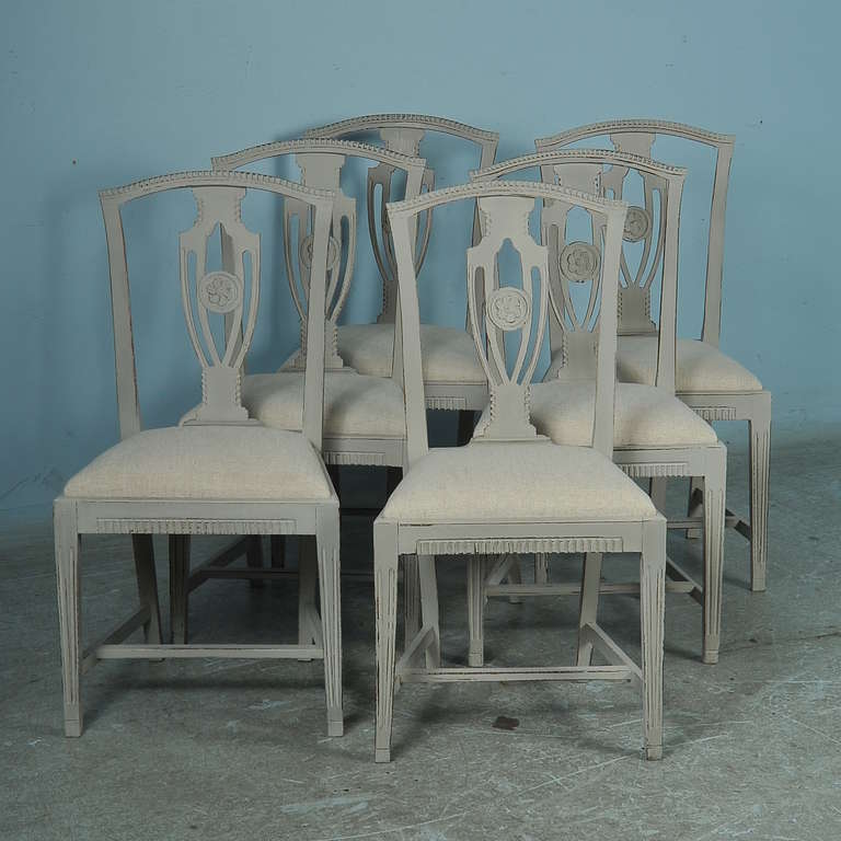 Classic set of 6 side chairs from Sweden circa 1910. They have been restored and painted in the old classic Gustavian style with a soft gray painted finish. The seats are newly upholstered in linen. This lovely set of dining chairs are ready to be