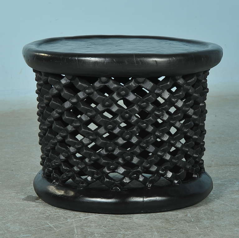 This African side table is made out of a hollowed out tree trunk. It's dark color and intricate detailed carving add to the intriguing organic feel of the piece.  This style of table can be combined with another of different size to create a unique