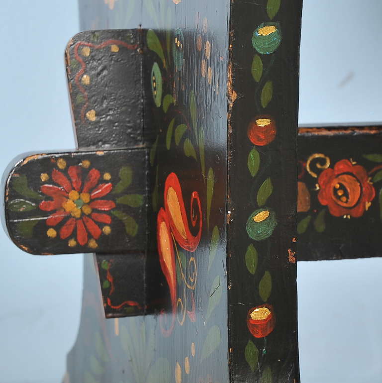 The colorful paint is all traditional on this small trestle table from Hungary. The background is black with hearts, various flowers and leaves depicted along the top, sides and trestle base. It's size allows it to serve as a small kitchen table,