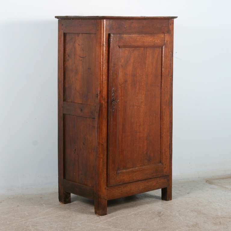 This scale of this one door cabinet/armoire is quite unique, the small size allowing it to be used in a wide variety of spaces. The  patina of the lovely chestnut wood is rich and deep, reflecting many years of use. It is in superb original