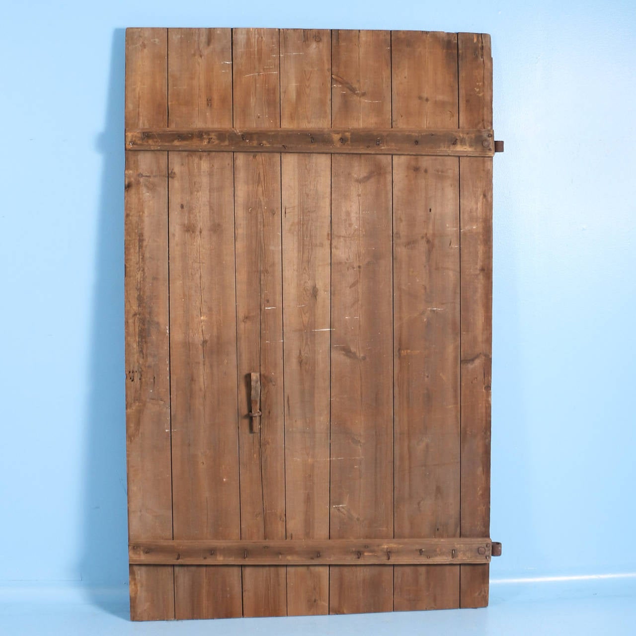 This very large barn door has an aged, weathered look due to years of constant use outdoors. The wood and iron have great character, please examine the close up photos to appreciate these details. This door will be perfect to hang on a sliding