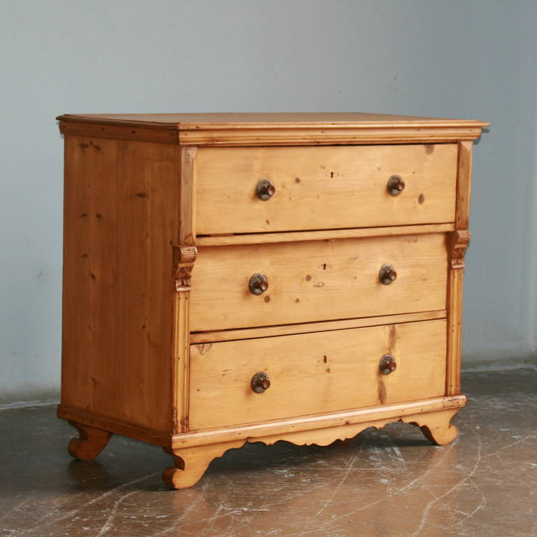 The beauty of this large chest of three drawers is the simplicity of the lines and large, spacious drawers. The drawer pulls are a slightly darker pine, and complimented by a pressed tin decorative element that together create a 