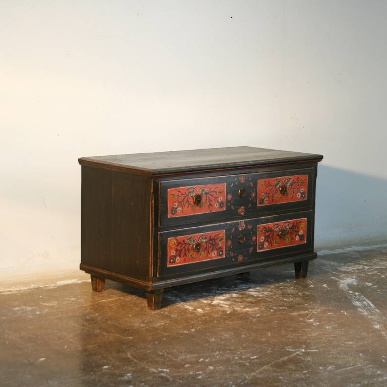 The paint is all original on this wonderful chest of drawers from Romania. The chest is painted black, while the drawers are painted with a traditional red floral motif. Please examine the close up photos to appreciate the detail of this folk art 