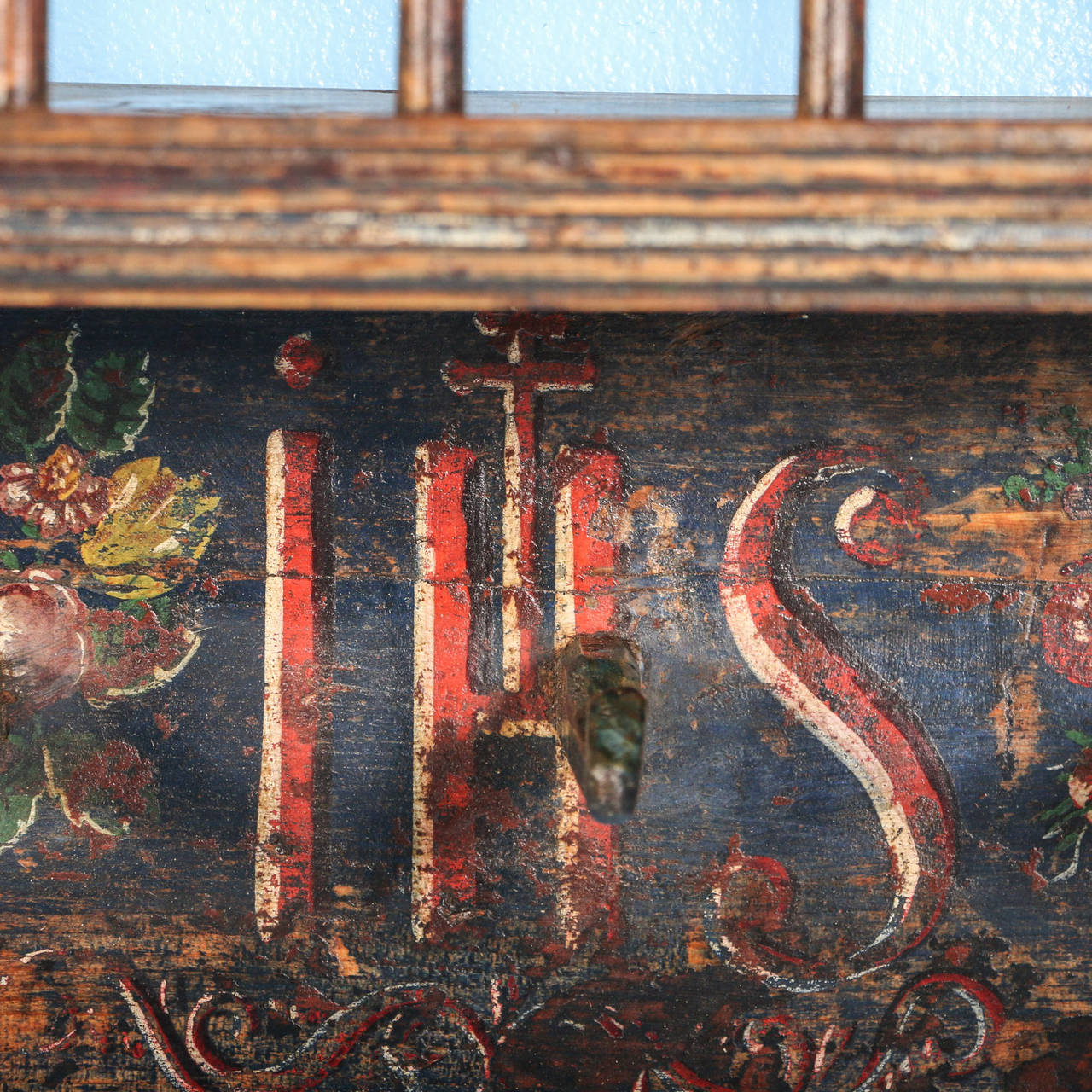 The beautiful dark blue and rich red are all original paint in this hanging shelf from Hungary. The flowers are a traditional folk art style, while the central monogram of 