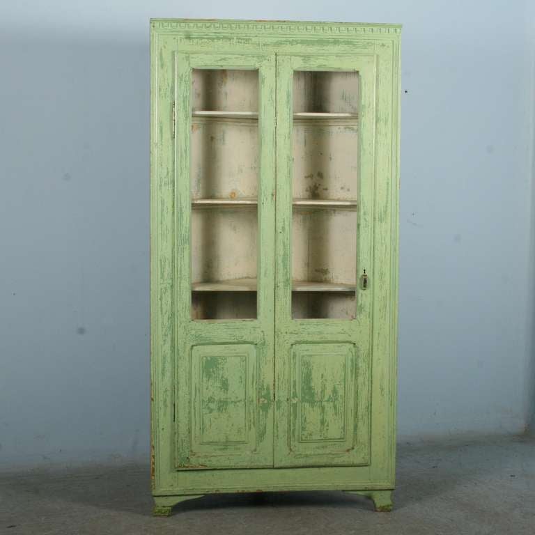 The soft green and interior pale white paint of this Swedish corner cupboard are all original and add to its charisma and charm. The door is hinged in the middle, allowing you to securely open only half (thanks to 2 wooden latches on the inside) or