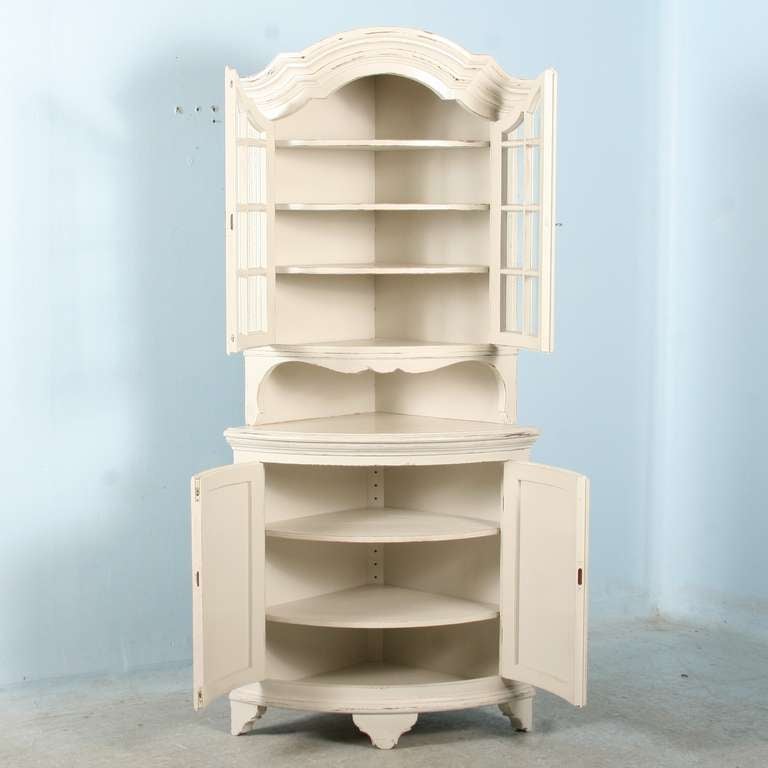 Lovely curves accentuate the beauty of this graceful corner cupboard from Sweden. The upper cabinet has glass doors, perfect to display collectibles. The upper shelves are fixed, while in the lower cabinet with paneled doors, the shelves are