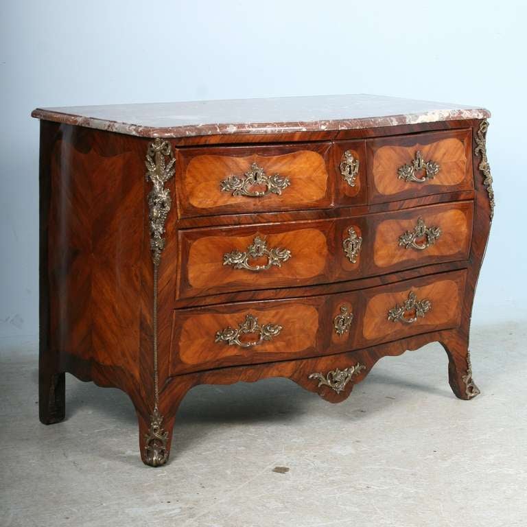 French Regence rosewood veneer commode, with shaped marble top, gilt bronze pulls, escutcheons and trim. Rich colors in the wood inlay, very good condition including marble top. Please review close up photos to examine the exquisite craftsmanship of