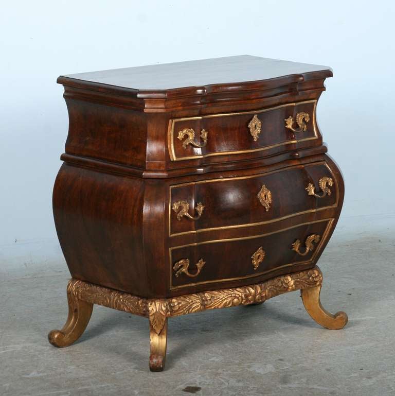 The beauty of the wood, gilt, and curvaceous Bombay design of this small scale Rococo chest of 3 drawers combine for stunning impact. The design is in the style of Mathias Ortmann (ca. 1700-1757). Please review the detailed photos to appreciate the