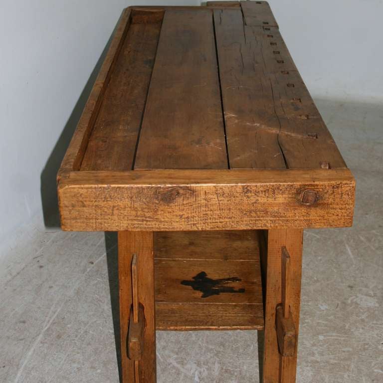 This wonderful carpenters workbench has a rustic patina from the many years of constant use. It has been restored and waxed, so is functionally strong and ready for use. Old workbenches like this one area often used as console tables today.
