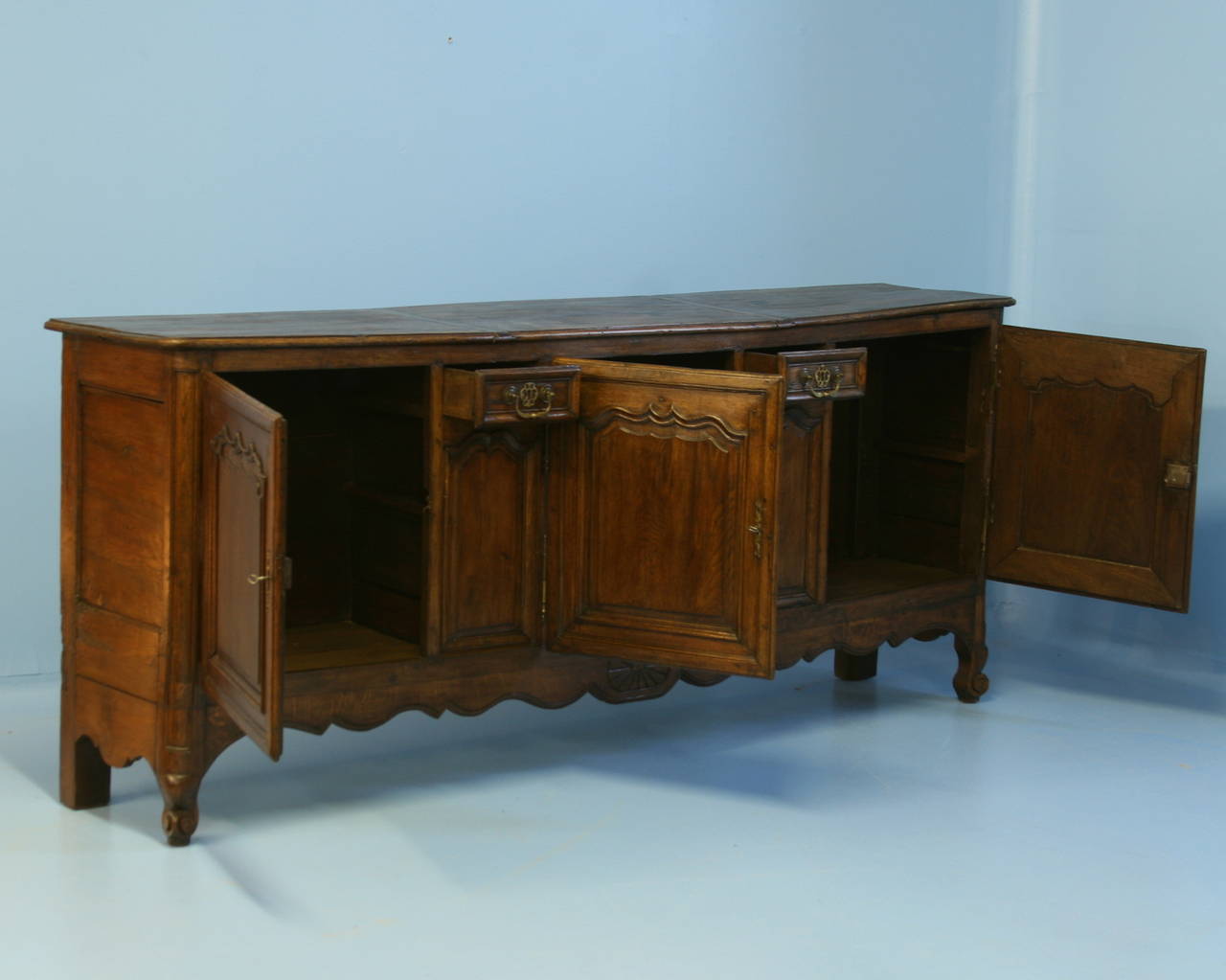 Visually stunning at over 8' long, this impressive French sideboard is a wonderful find. Please examine the close up photos to appreciate the rich depth and patina of the wood and the distinctive French style of carving along the paneled cabinet