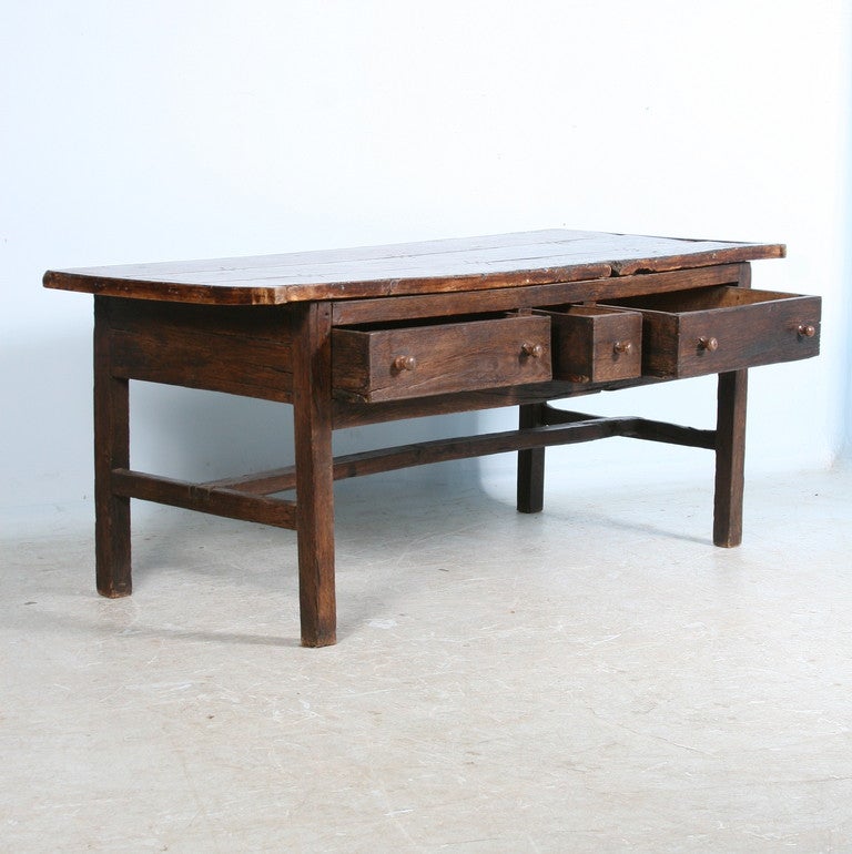 This is truly an amazing table; the deep patina and rich depth of the wood reveal its age and years of use. This table would be stunning behind a sofa with lamps or artwork displayed on it, or could even be cut down into a remarkable large coffee