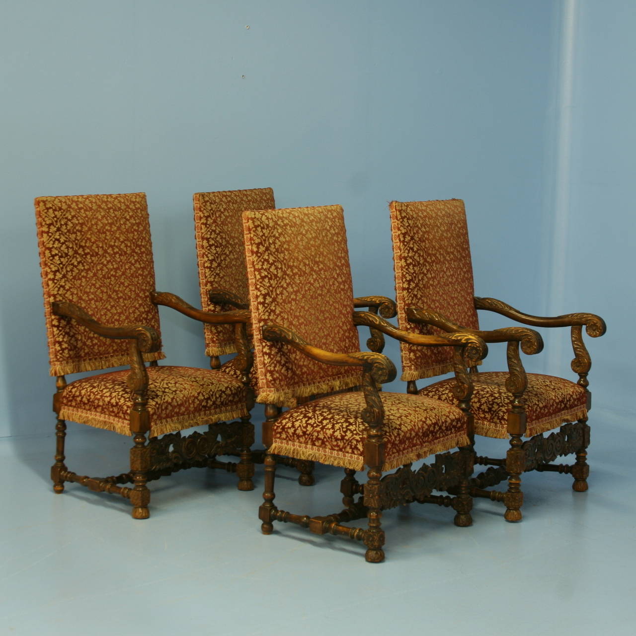 Set of 4 matching baroque oak carved arm chairs from Denmark. Please note the beautifully carved arms, feet and stretcher on this handsome set. These are typically found in pairs, unusual to find a large matching set of 4. The upholstery is old, but