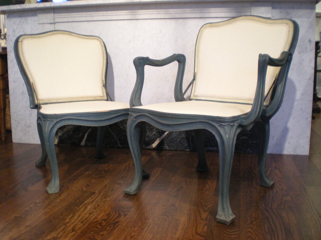Pair of painted chairs with seat and back upholstery. Backs of chairs are covered in metal and can be folded down and used as stool or table. Bottom of the feet are also covered in metal. Sold as pair.