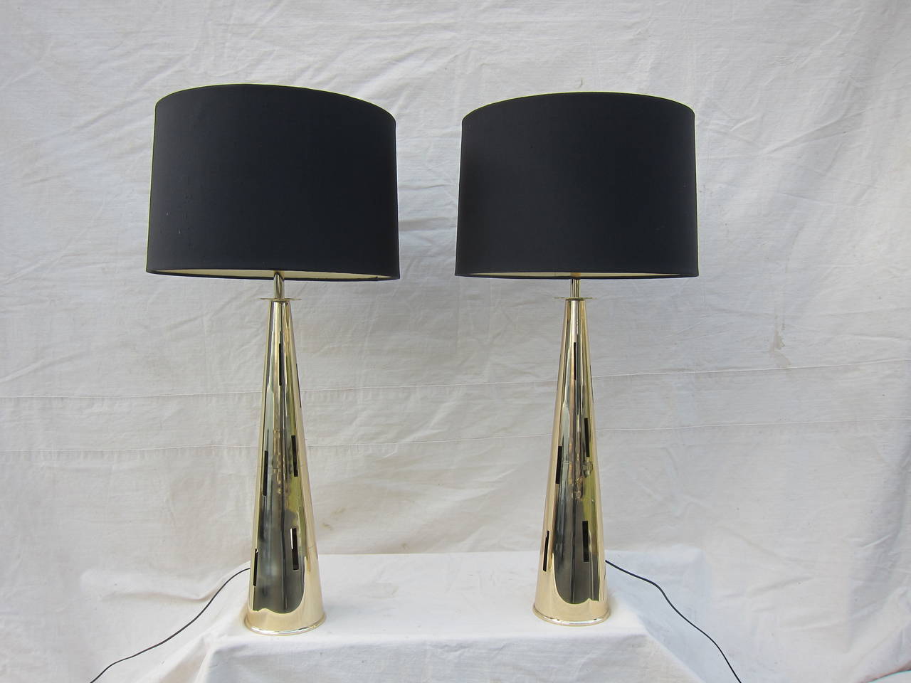 Italian Mid Century pair of  Brass Table Lamps of exceptional quality in the Style of Gio Ponti.  Concial Shaped with varring sized window cut openings.  Rewired with full dimmer controlable sockets and new Silk Shades. Excellent condition. 