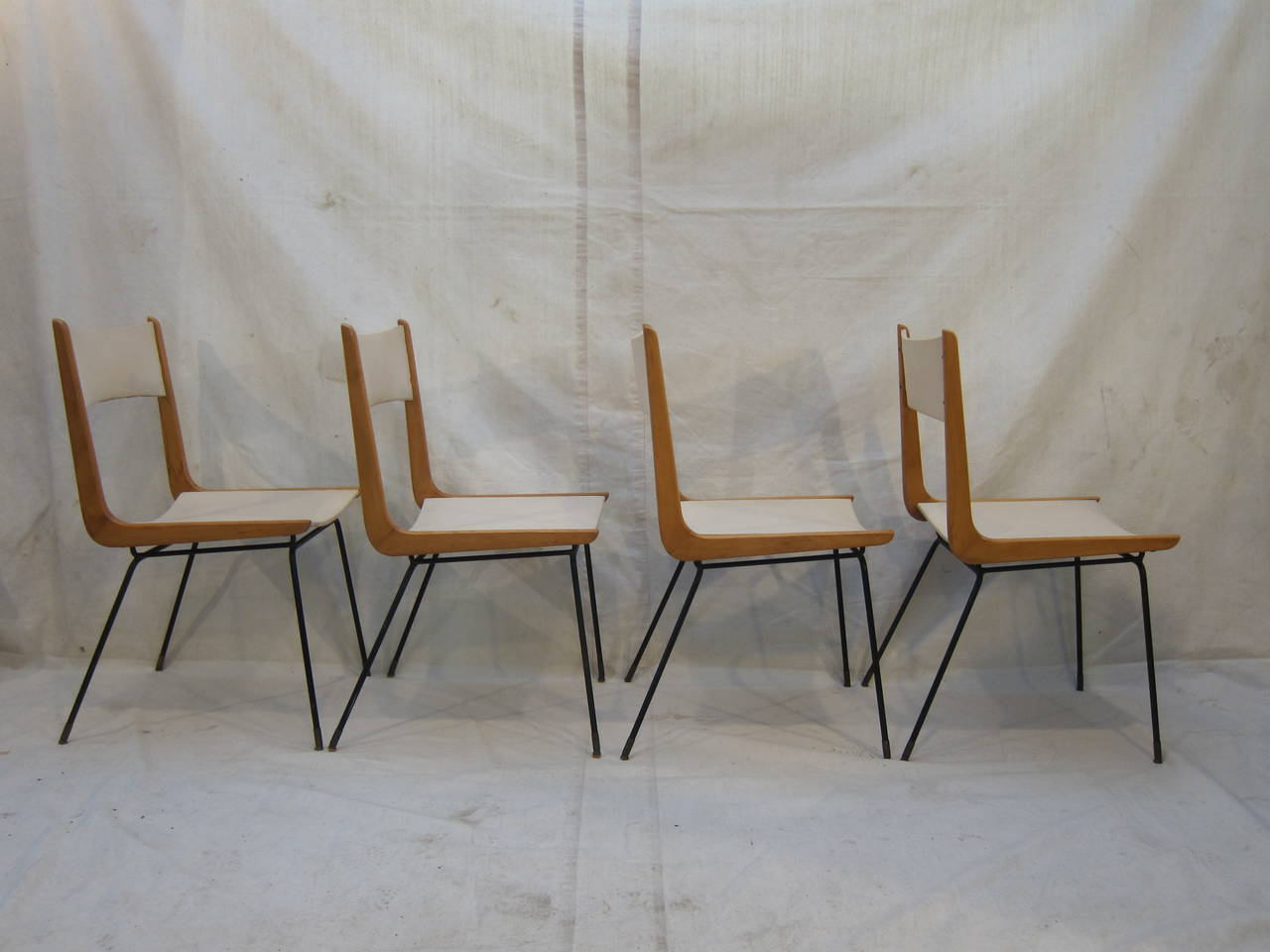 Rare set of four Carlo Di Carli Boomerang dining Chairs. Original Lorica covering. In good original condition. Iron with bronze feet, Ash wood boomerang frames connecting seat and backrest to legs.  New covering is recommended.
