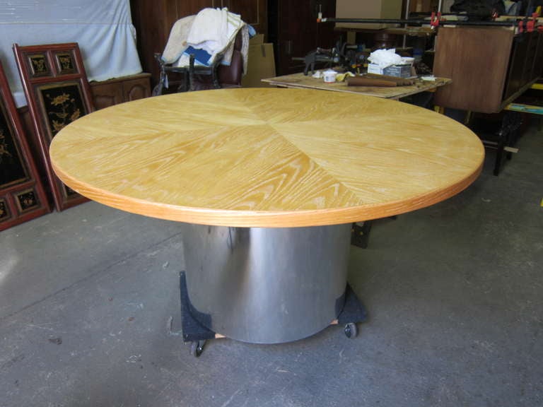 Custom built Gunderson round dining table, cerused oak on chromed panel cylinder base, circa 1975 this item was a custom order, one of a kind.
Please note pictures show table on a furniture dolly only for the ease of movement. Cylinder base shows
