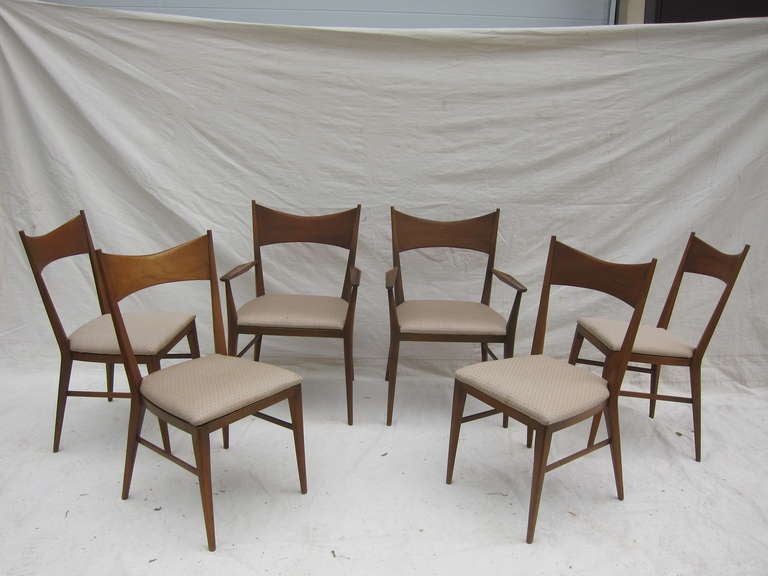 Paul McCobb For Calvin, set of six Bow-tie dining chairs, two arm chairs and four side chairs.   In house refinishing and reupholstering  available for an additional fee.
Please note this Chair set is part of a complete Pual McCobb dining suite.