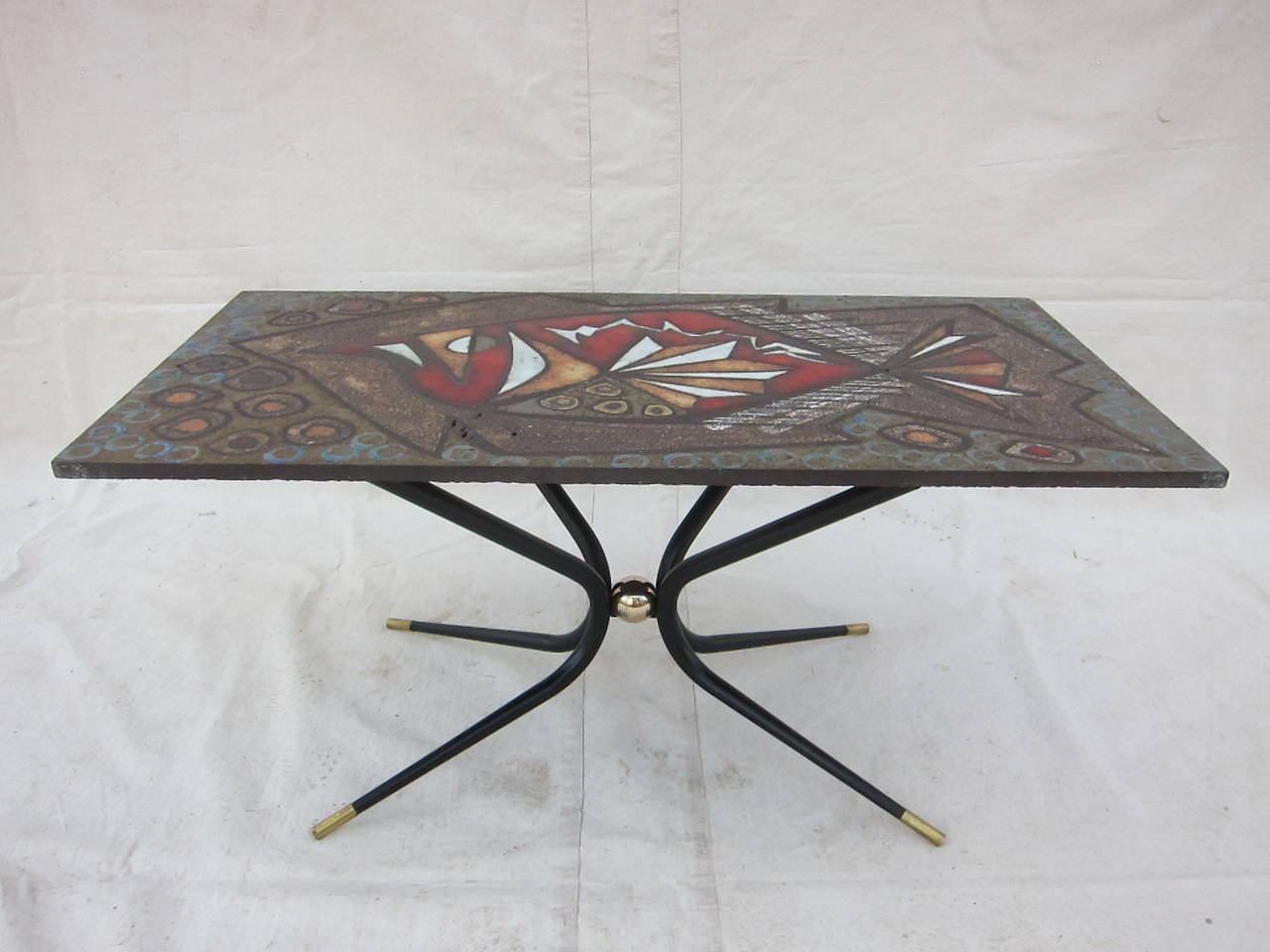 A rare and singular cocktail table in the style of Gio Ponti. The table is completely hand made of a very fine quality. Tabletop is one of a kind Artisan solid one piece tile hand etched painted and glazed signed JGP.  The tile is fixed to sculpted