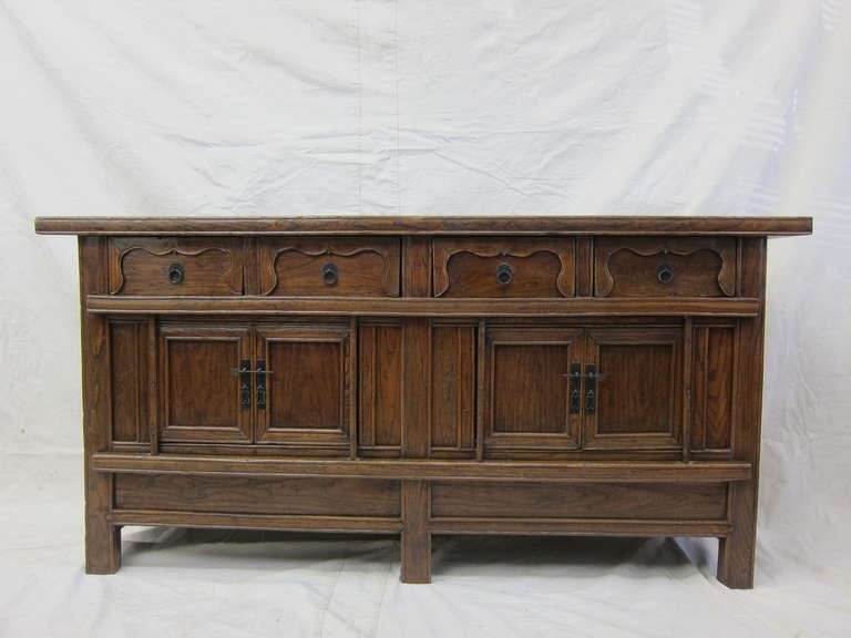 19th century Provincial sideboard. Panel doors, curtain aprons on drawer fronts, with hidden storage inside the false bottom. Elm wood natural color having a refined country appeal. Excellent storage and serving capacity. Very good condition, circa
