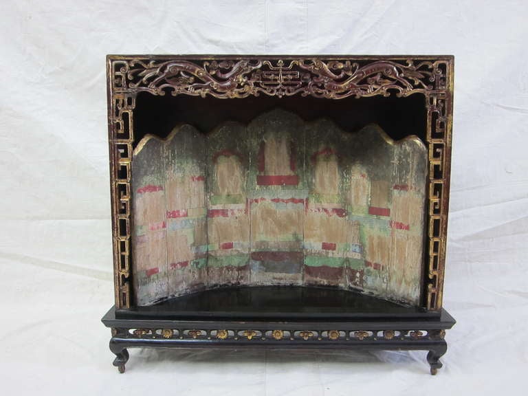 Rare 19th century Shrine Black lacquer with stage back panel painted as theater.  Intricately carved detail of double dragons, long life symbol, with scroll work up sides.  Set upon a cabriole leg table with carved lotus fret waist, set on top