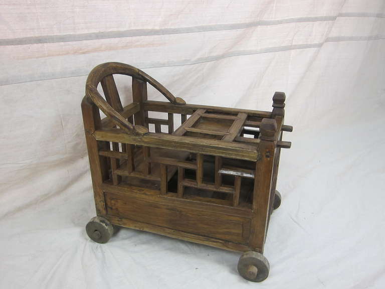A 19th century baby minder cart.
Used to keep a baby or infant in while working. This cart could be rolled around for easy movement. Can be used as side table, storage, decorative. Rustic raw wood.