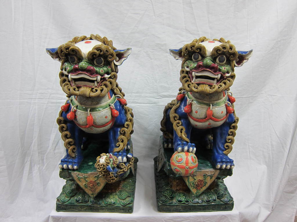 Chinese ceramic foo dogs, 20th century, with Fusan (artisan) stamp in back. Outstanding hand work as all the details each protruding element was formed by hand and applied to each of the dogs bodies. The dogs separate from the stands which makes