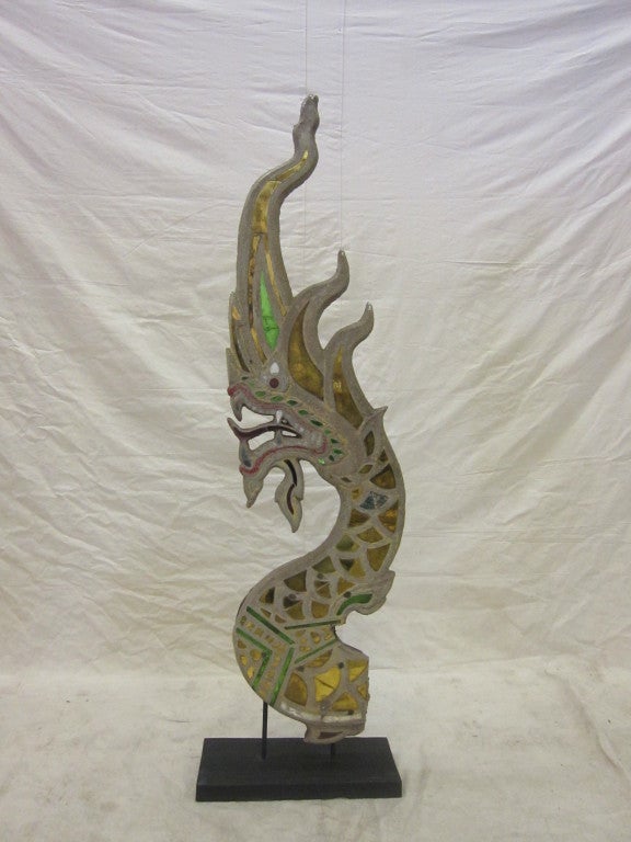 Thai Dragon Naga Sandstone type aggregate with inlaid mirrored glass. Remnants of the wood carved back support. This is a fragment of a Naga sculpture, building element, used mostly on Temples. Naga is a mythical dragon type guardian of treasure and