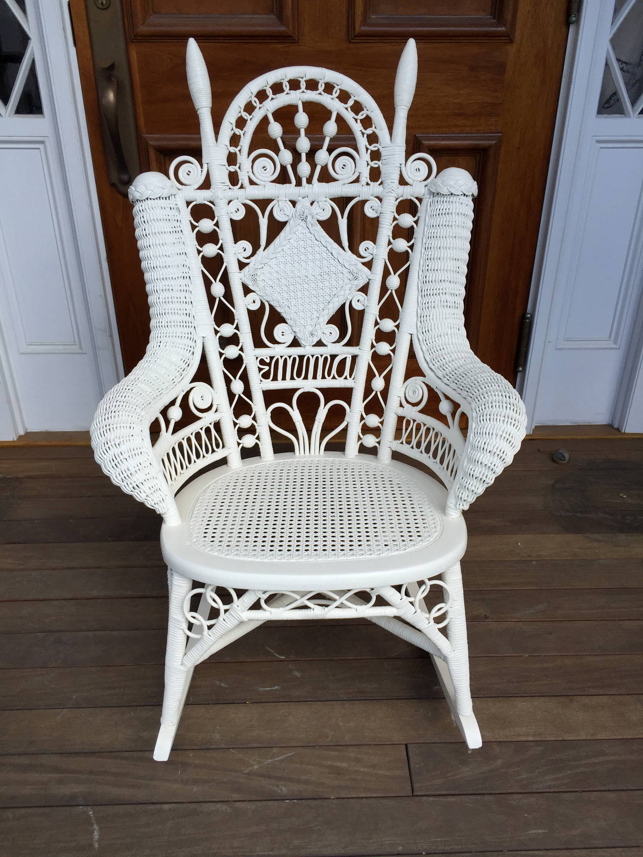 Lovely and dainty wicker rocker with the name "Emma" woven into the back. Rocker measures 39"tall, 27"wide and 32"deep.